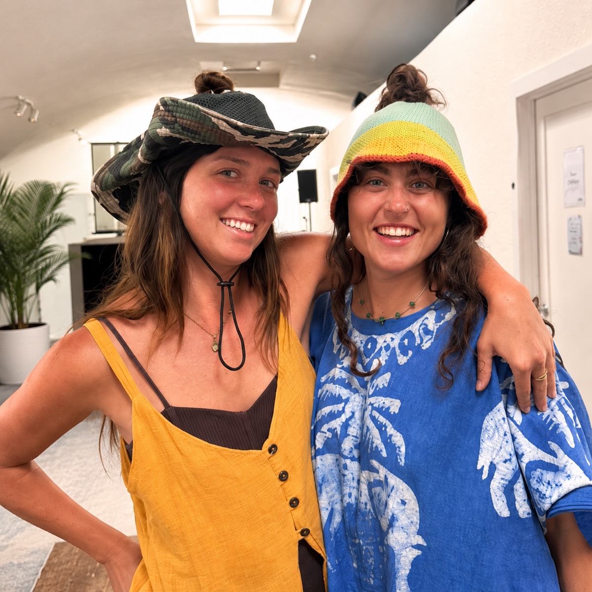 Two friends in HolyHats, arms around each other