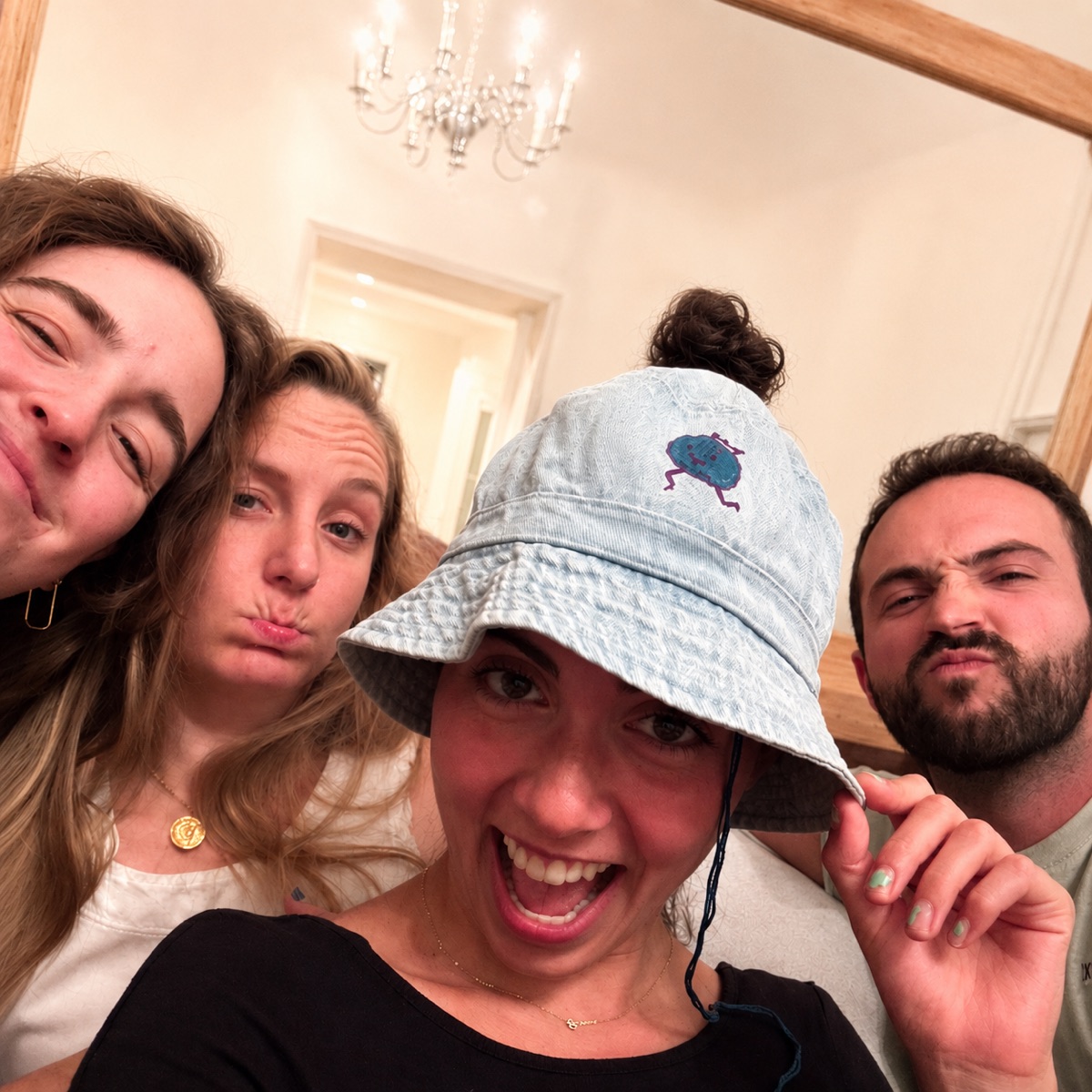 Friends crowding in around a denim HolyHat